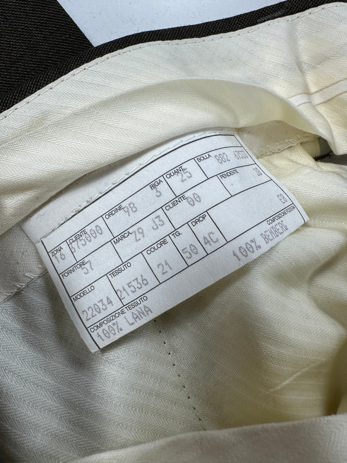 Scheda di commessa cucita sulla fodera avorio del pantalone Garrett's
