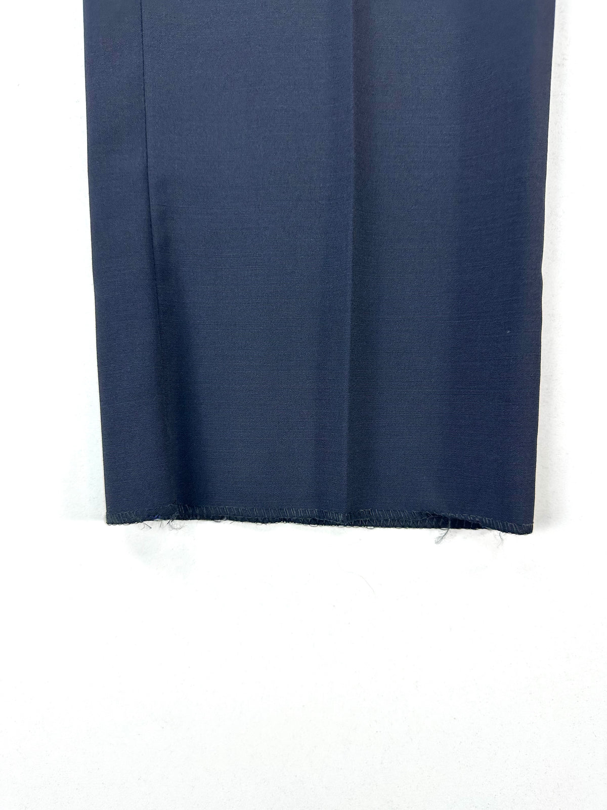 Dettaglio del fondo del pantalone lasciato grezzo, non orlato