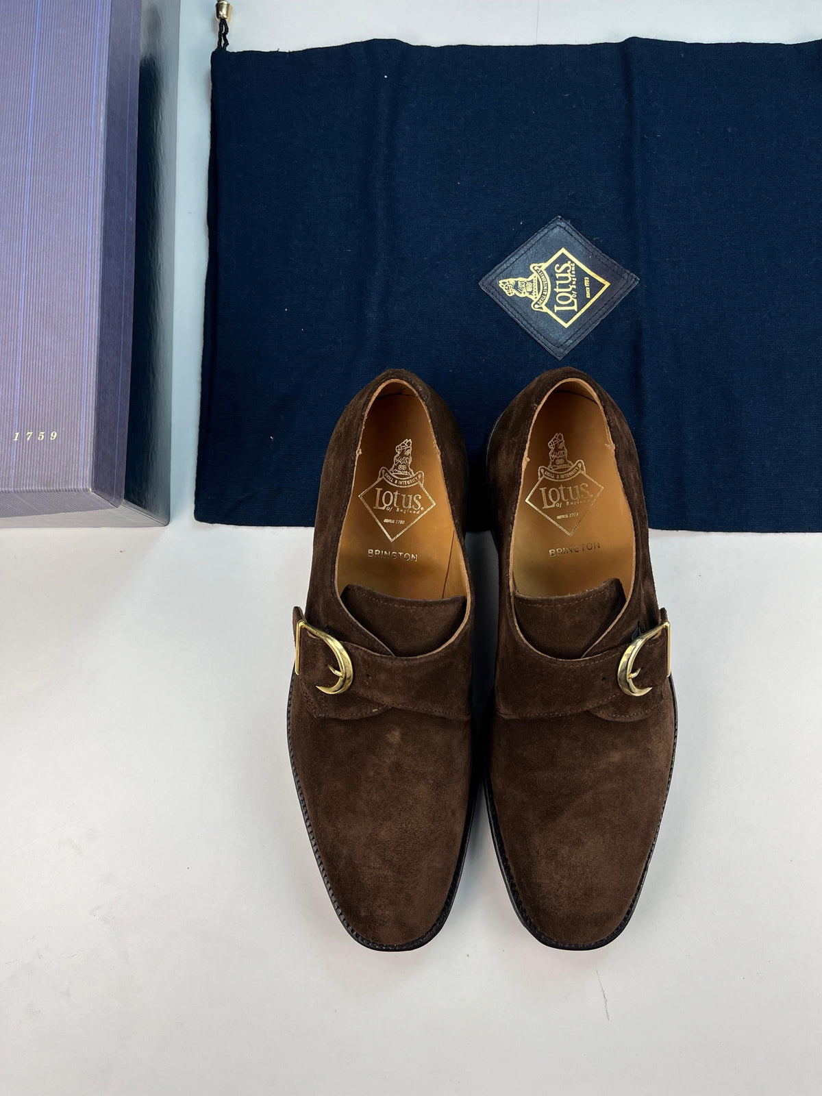 Monk strap Lotus of England Brington in pelle scamosciata marrone scuro viste dall'alto, con soletta logata Brington, sul sacchetto con logo Lotus e la scatola a lato