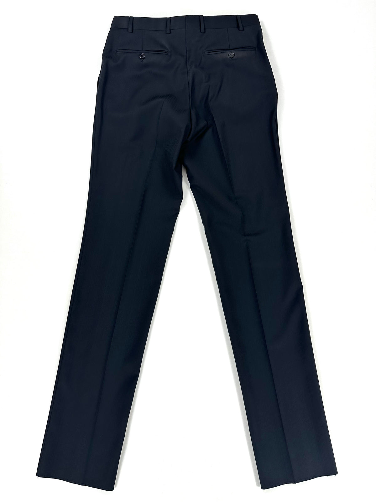 Gambe del pantalone distese, con la piega centrale in evidenza