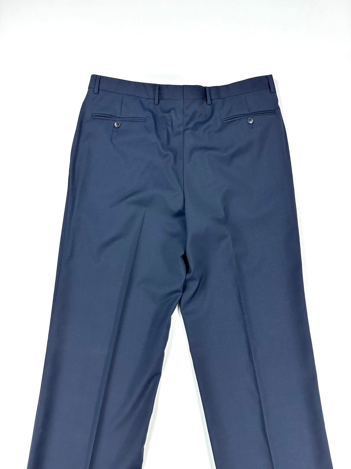 Retro del pantalone blu con le due tasche posteriori a filetto abbottonate