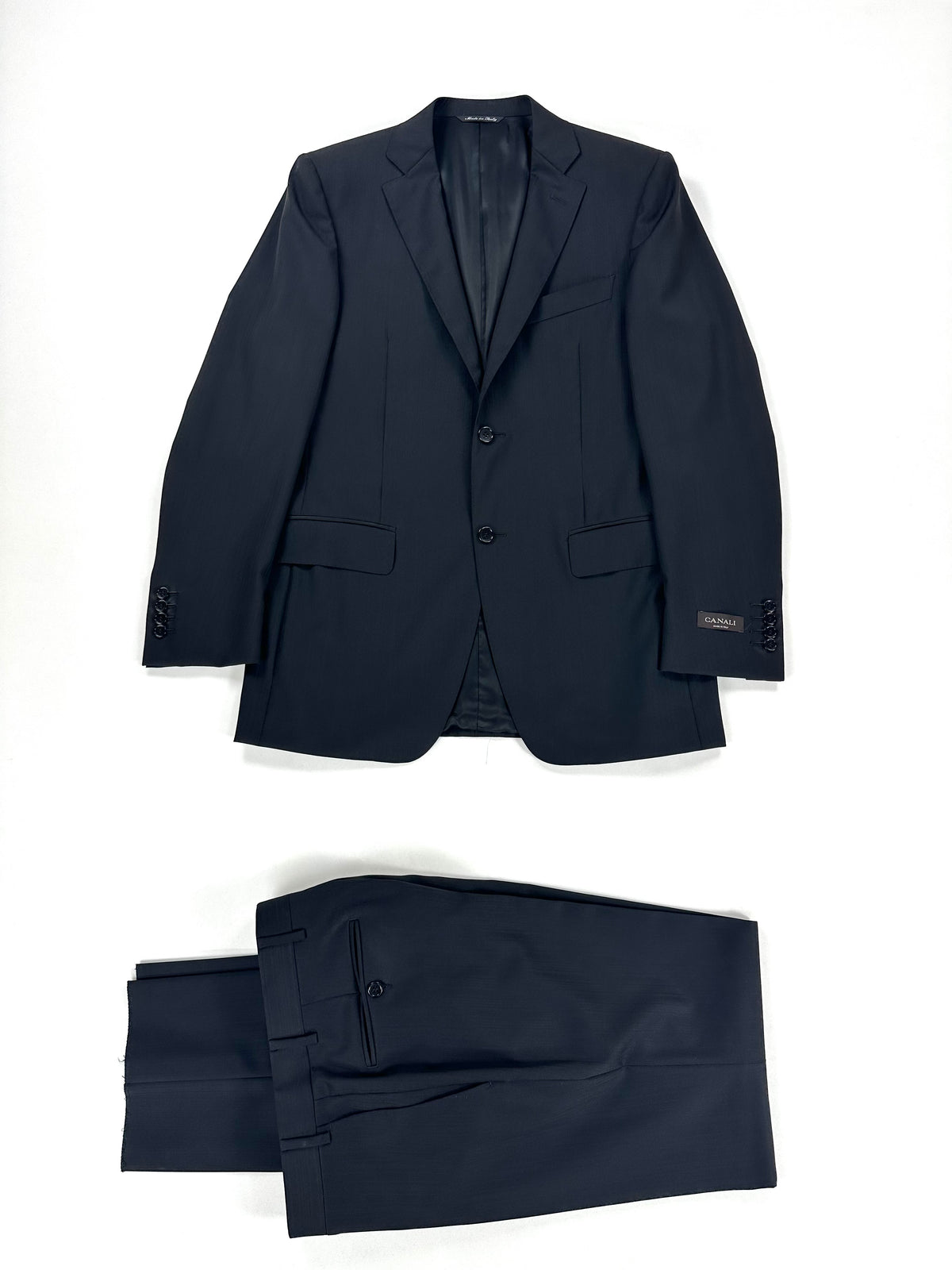 Completo Canali gessato nero: giacca e pantalone coordinato distesi su fondo chiaro