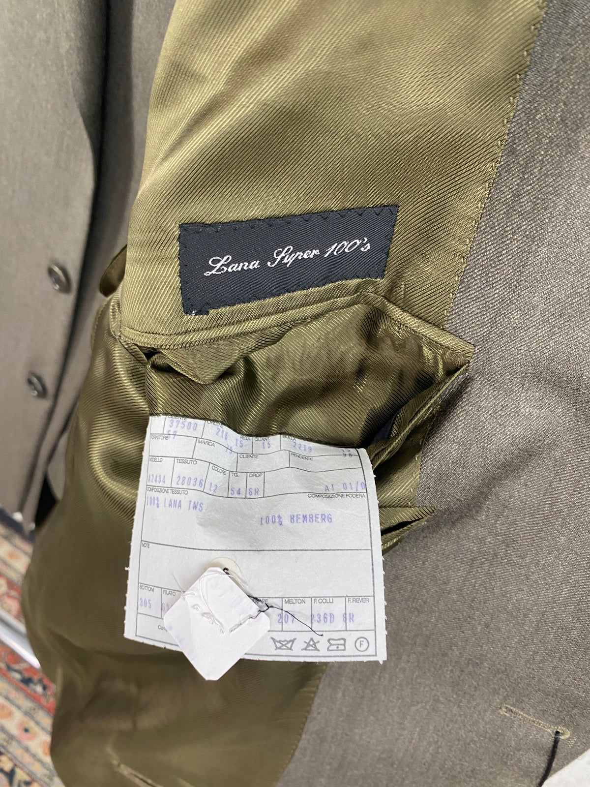 Etichetta Lana Super 100's e scheda di commessa nella giacca Garrett's verde cachi