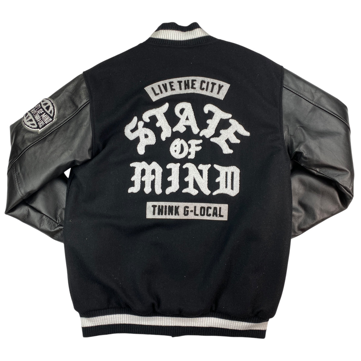 Retro della giacca varsity State of Mind con macro logo tra le scritte Live the City e Think G-Local e patch sulla manica in pelle