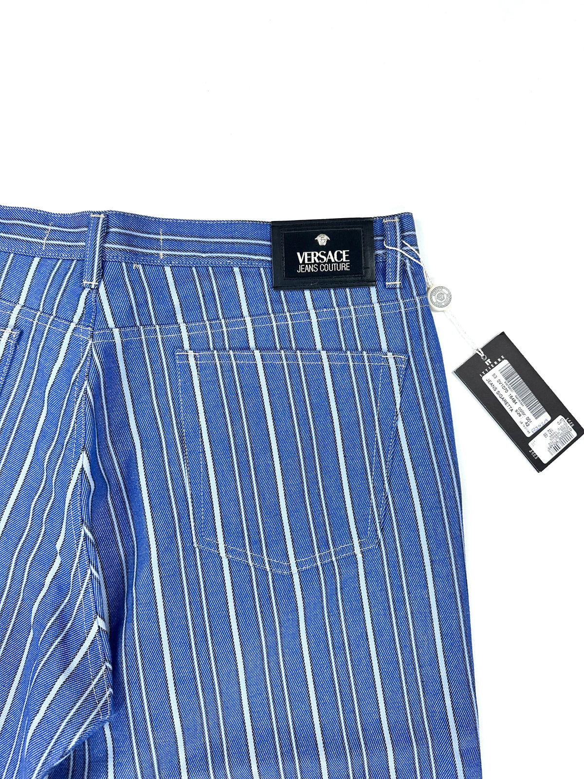 Jeans ripiegato che mostra fianco e cartellino del marchio appeso al passante