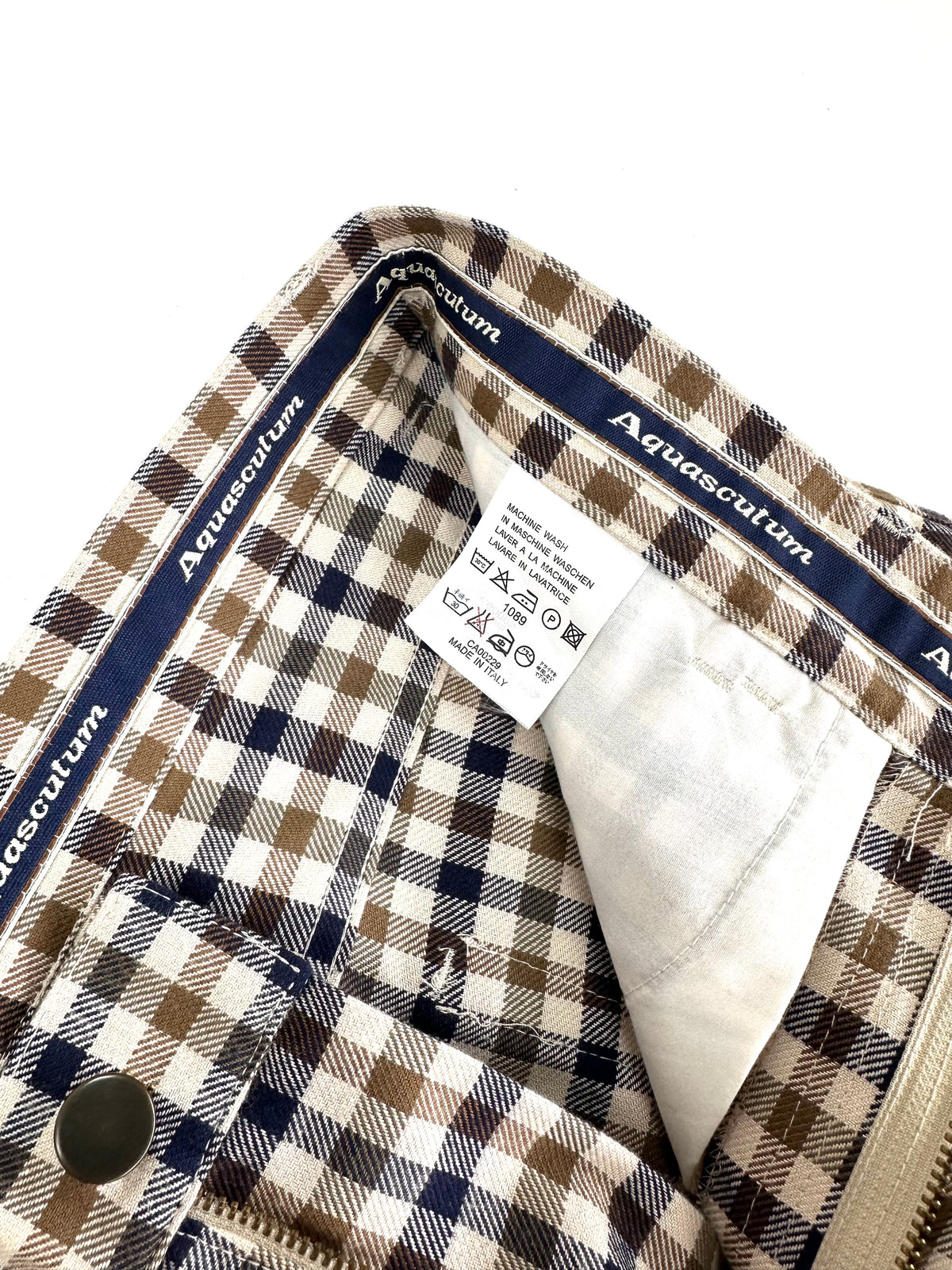 Interno della vita del pantalone Aquascutum con nastro jacquard del marchio ed etichetta di manutenzione