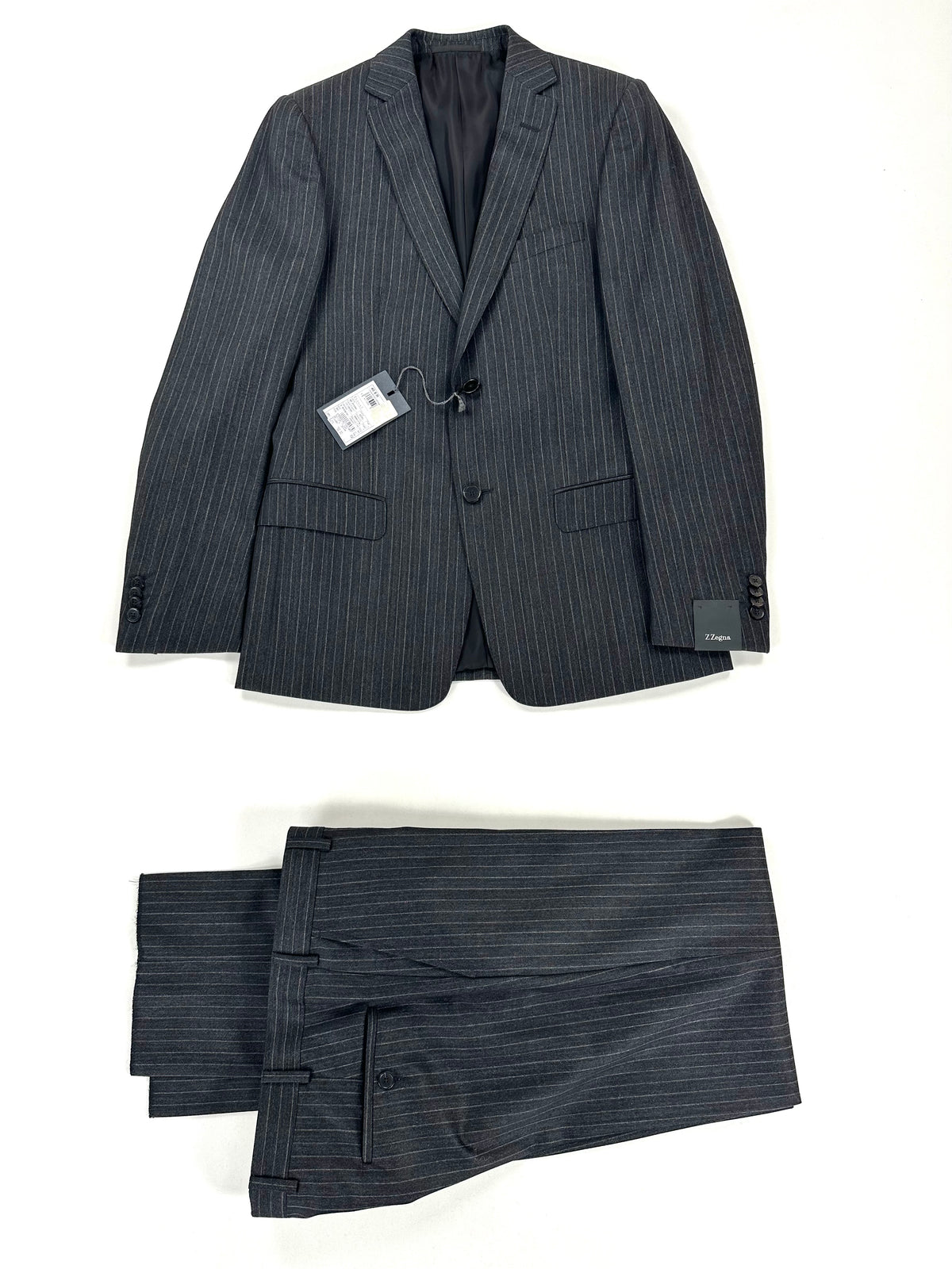 Completo Z Zegna gessato grigio scuro: giacca e pantalone coordinato distesi su fondo chiaro