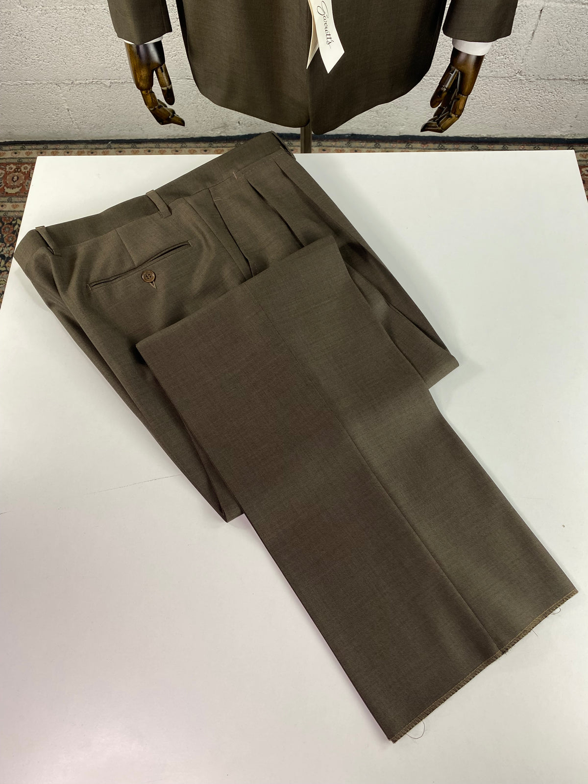 Pantalone Garrett's verde marrone piegato su piano, in ambientazione showroom