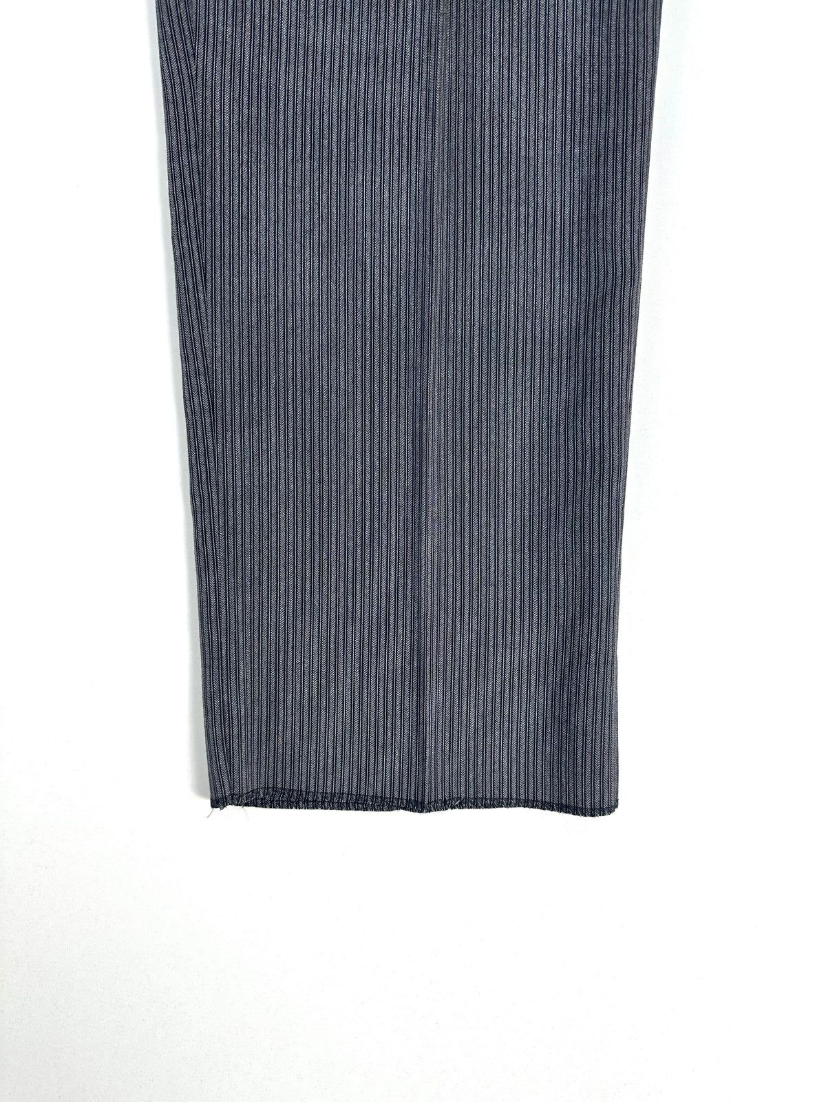 Dettaglio di una gamba del pantalone a righe ripiegata