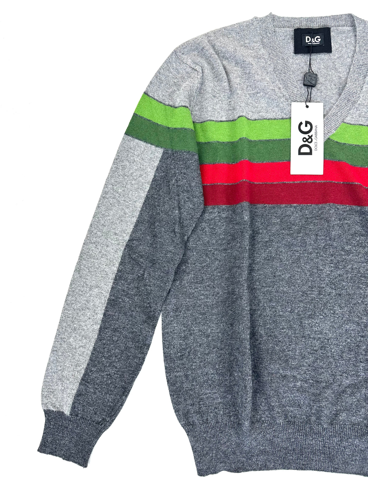 Maglione D&G visto di tre quarti, con manica distesa e targhetta sul petto