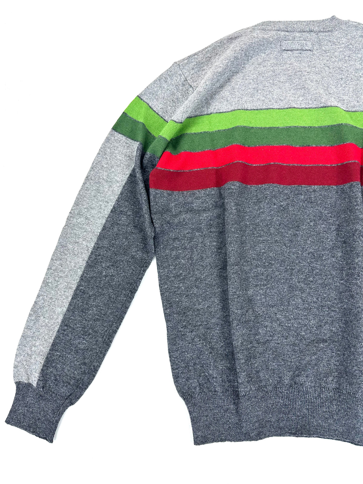 Fianco del maglione disteso, con manica lunga e polsino a coste