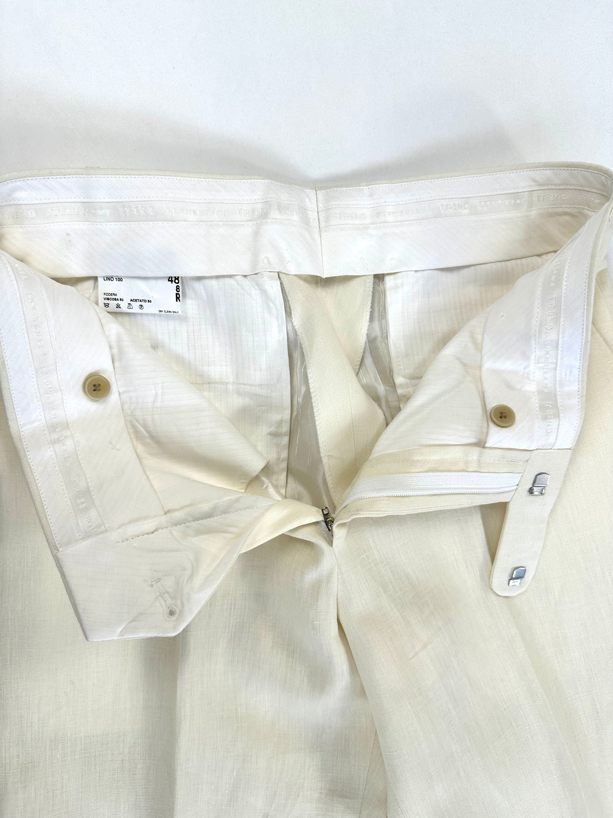 Interno del pantalone aperto: chiusura, fodera e finiture in vita