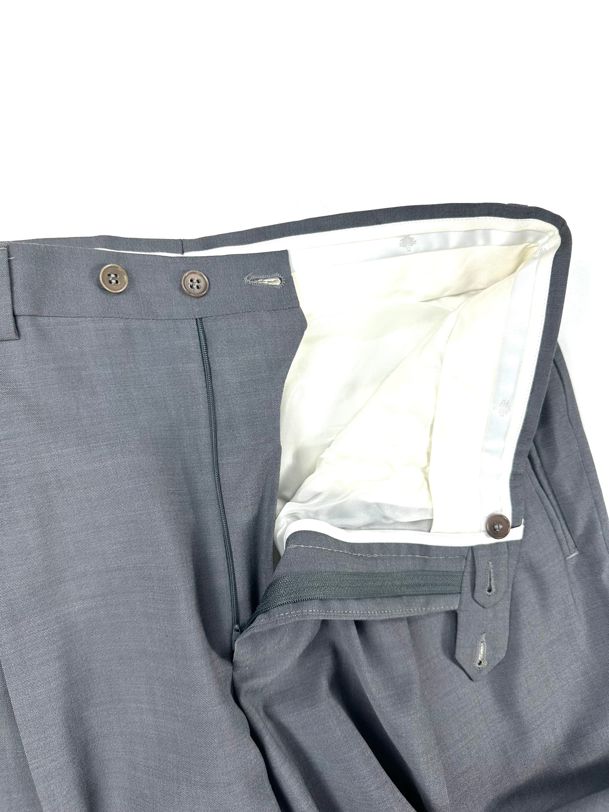 Vita del pantalone aperta: zip, doppio bottone di chiusura e fodera interna bianca