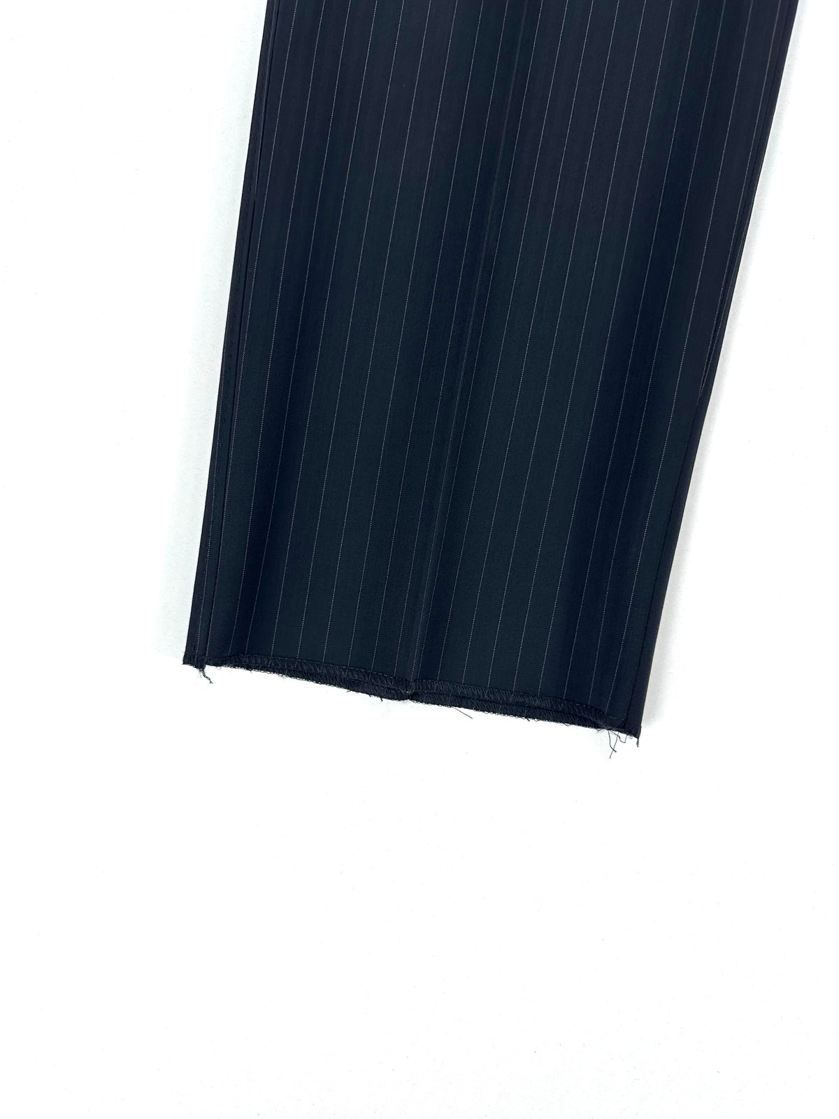 Fondo gamba del pantalone in primo piano, con il bordo del tessuto gessato