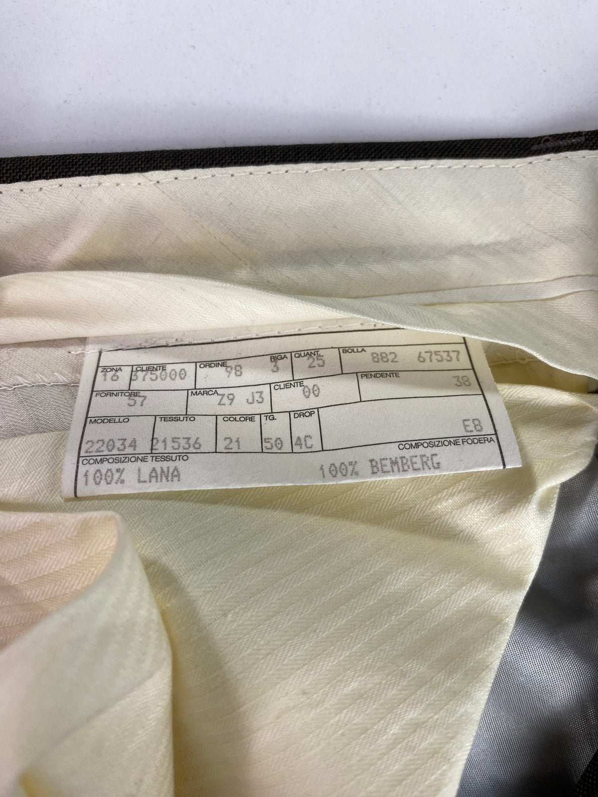 Scheda di commessa cucita sulla fodera avorio del pantalone Garrett's