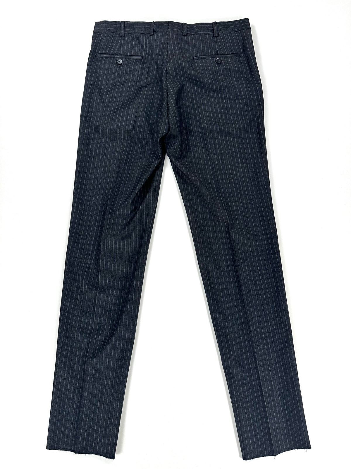 Gambe del pantalone distese, con la piega centrale in evidenza