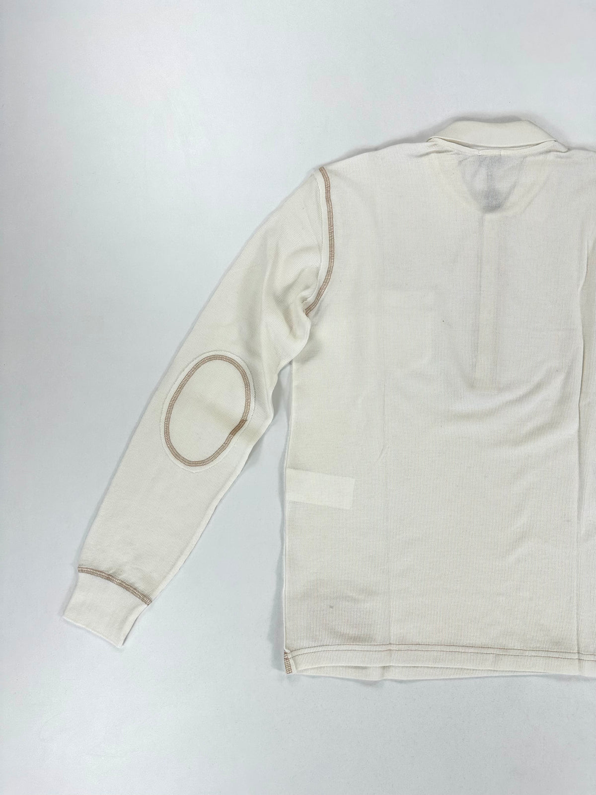 Fianco della polo disteso, con manica lunga e fondo in maglia