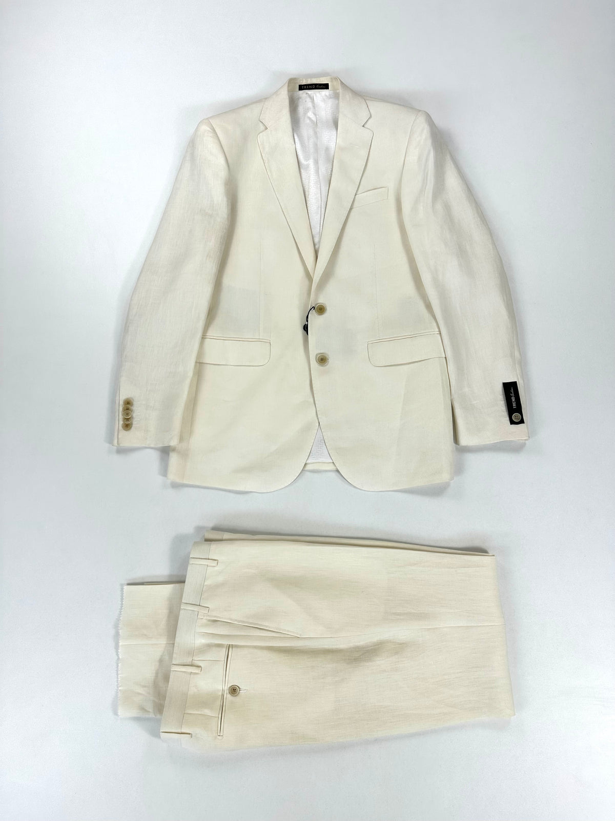 Completo Corneliani Trend bianco in lino: giacca e pantalone coordinato distesi su fondo chiaro
