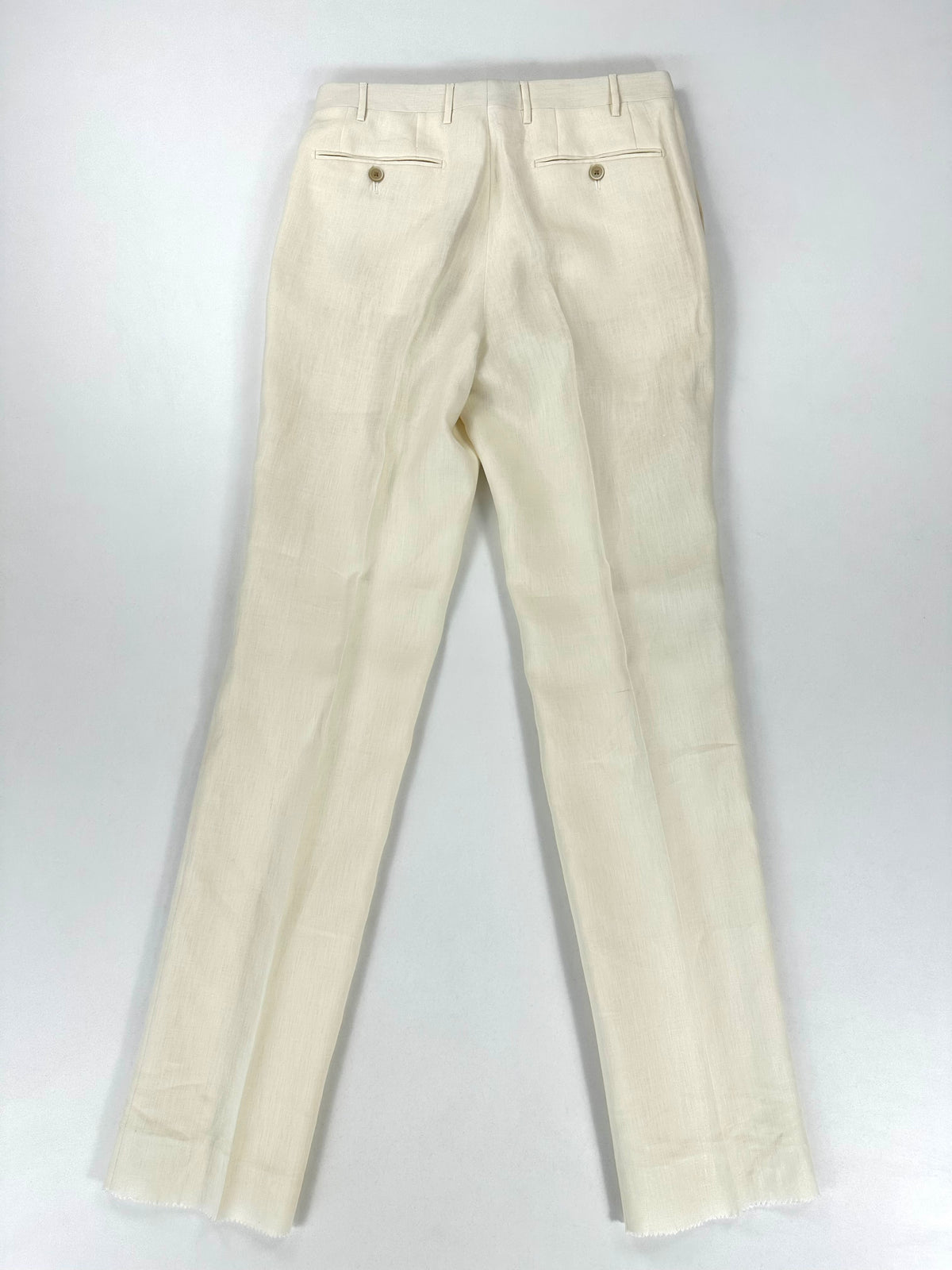 Gambe del pantalone in lino distese, con la piega centrale in evidenza