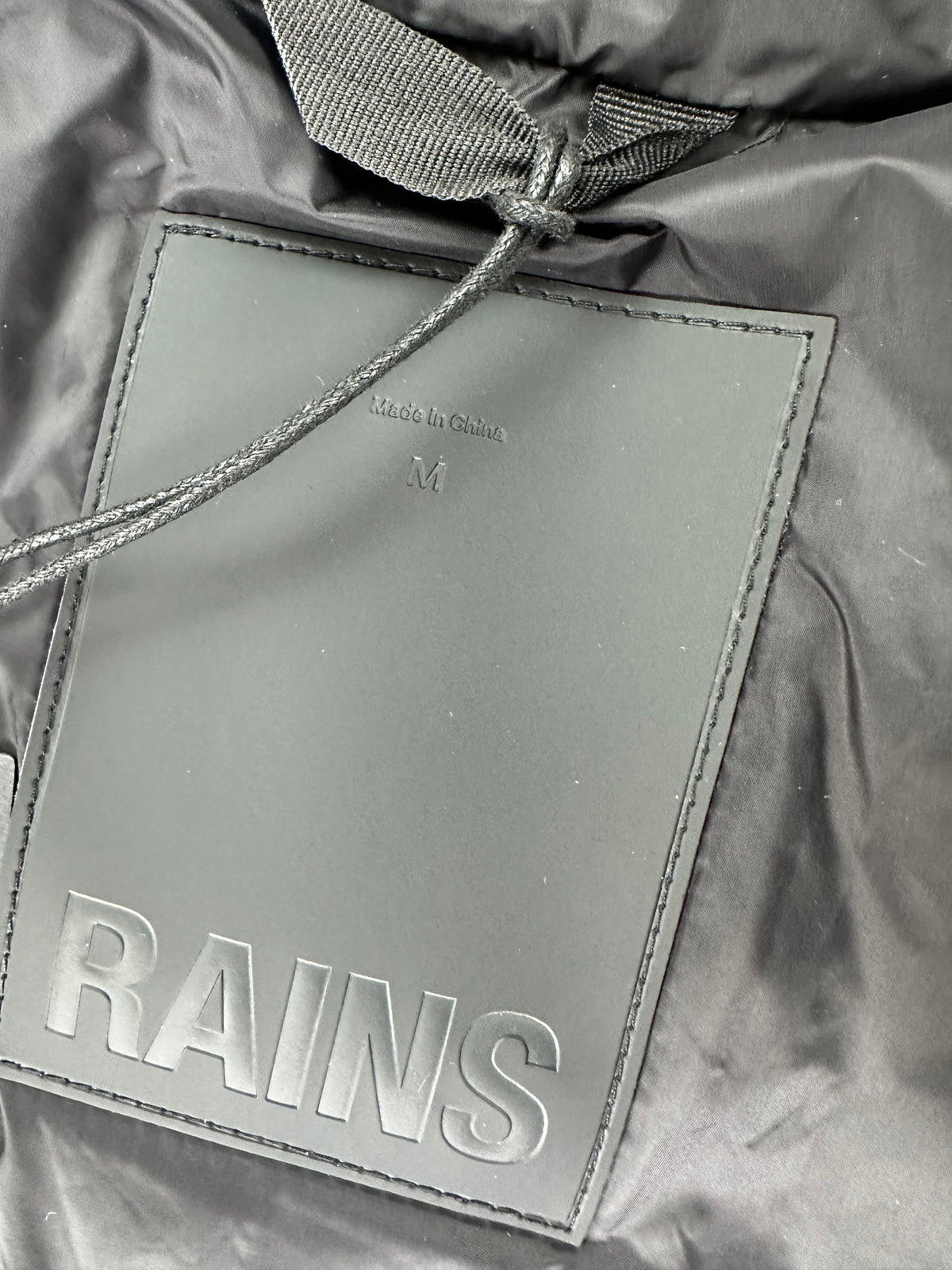 Patch Rains in gomma nera tono su tono e cartellino originale con listino € 189,00