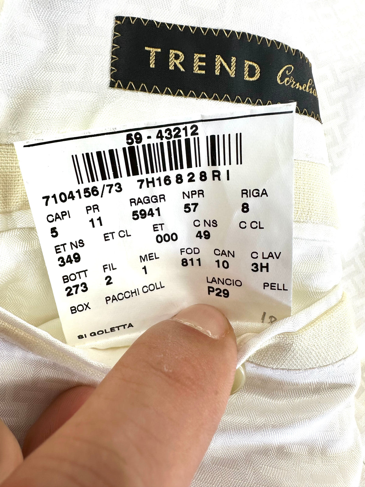 Cartellino Trend Corneliani con codici di produzione, tenuto in mano accanto alla fodera