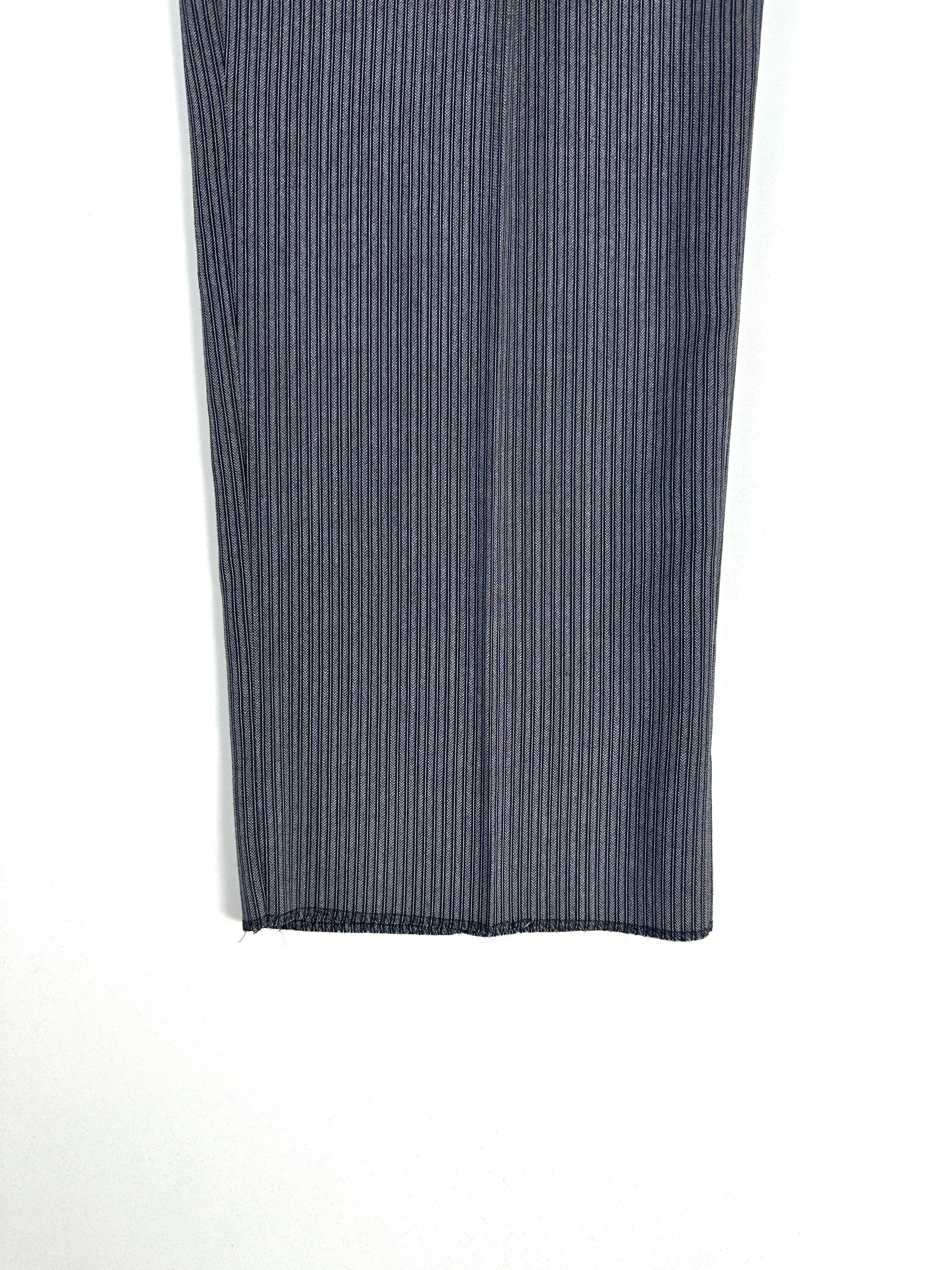 Dettaglio di una gamba del pantalone a righe ripiegata